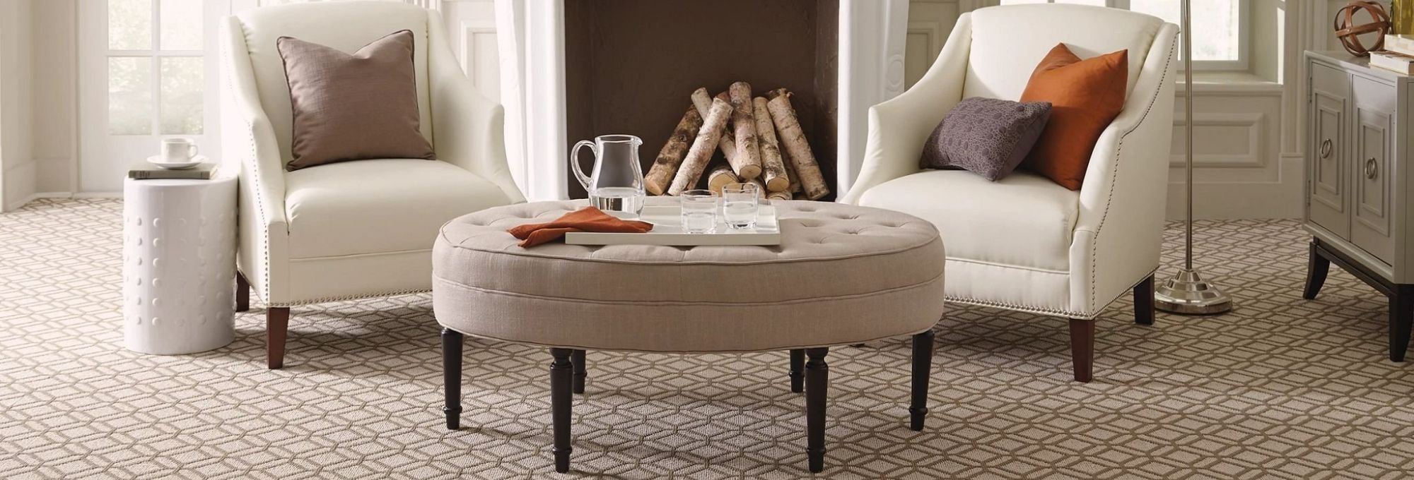 two white armchairs and a coffee table in a living room with patterned brown carpet from Carter Carpets & Vinyl in Temperance, MI